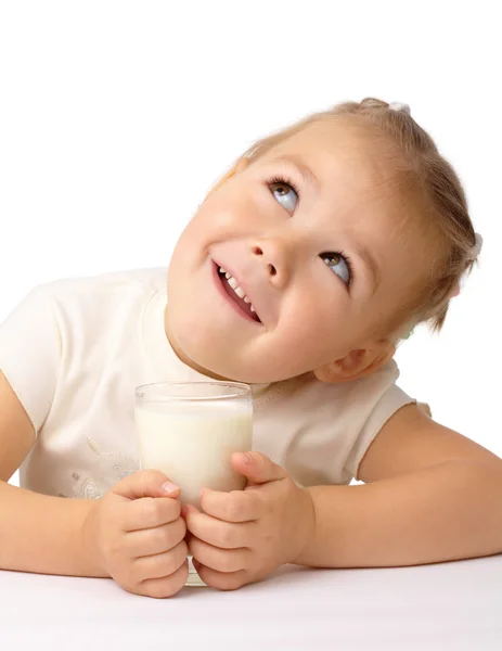 Niña con un vaso de leche mira hacia arriba —  Fotos de Stock