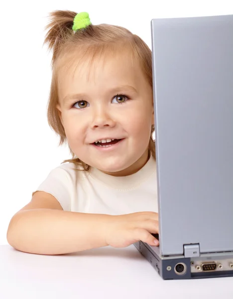Roztomilá holčička se dívá z její laptop — Stock fotografie