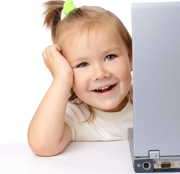 Söt liten flicka tittar från sin laptop — Stockfoto