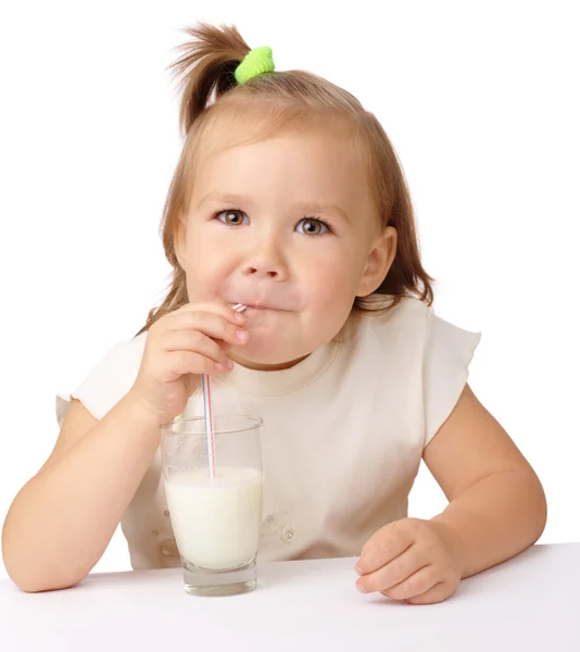 Маленька дівчинка п'є молоко, використовуючи питну солому — стокове фото