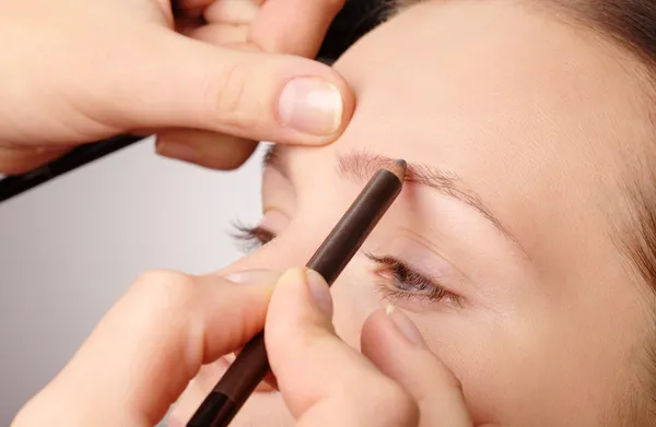 Penciling ögonbryn för ung flicka — Stockfoto