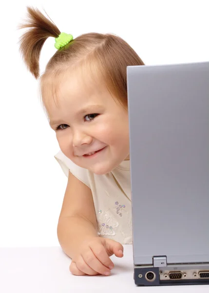 Linda niña está mirando hacia fuera de su computadora portátil — Foto de Stock
