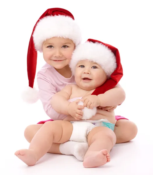 빨간 크리스마스 모자와 미소를 입고 두 아이 — 스톡 사진