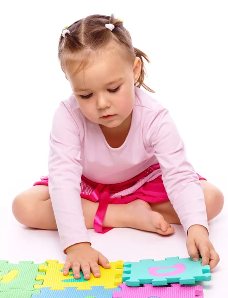 可爱的小女孩坐在地上 白上被隔绝在玩字母表 — 图库照片