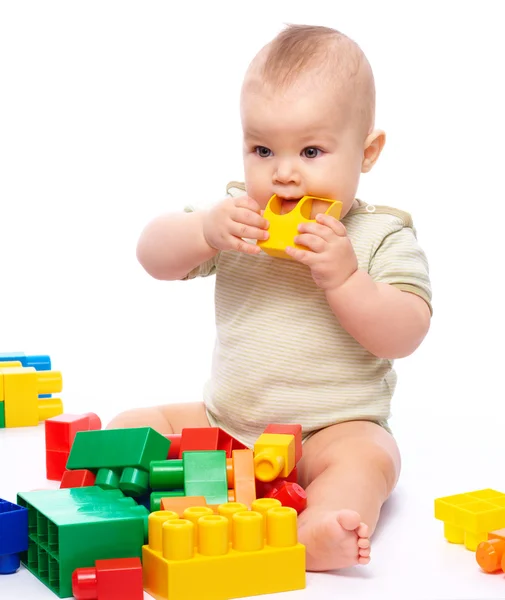 Milý Chlapeček Hraje Stavební Cihly Kousání Jeden Nich Zatímco Sedí — Stock fotografie