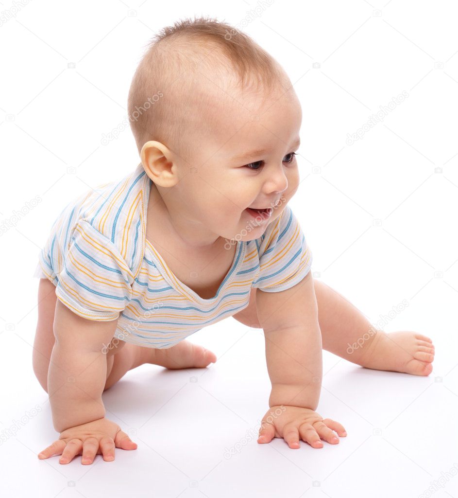 Happy child is crawling on floor and smile, isolated over white