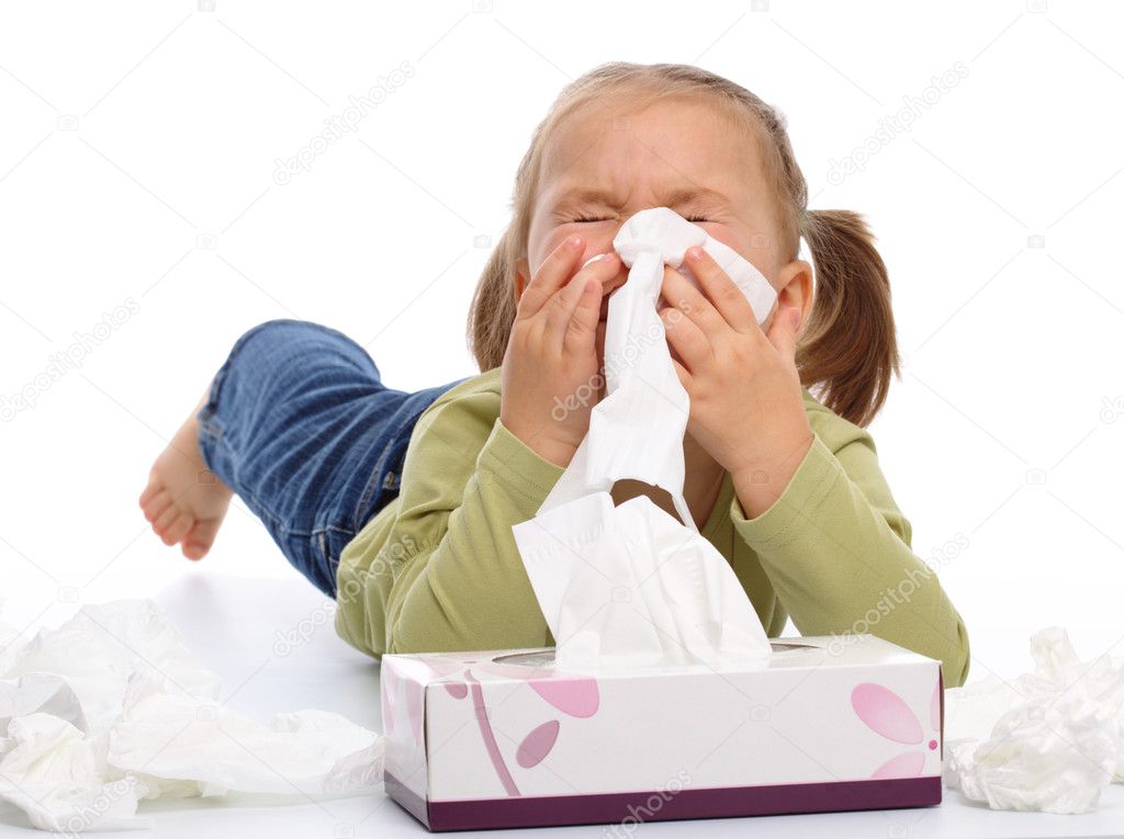 Little girl blows her nose while laying on floor, isolated over white