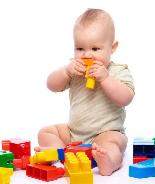 Aranyos Kisfiú Játszik Kiépítése Téglák Csípős Egyikük Ülve Földön Elszigetelt — Stock Fotó