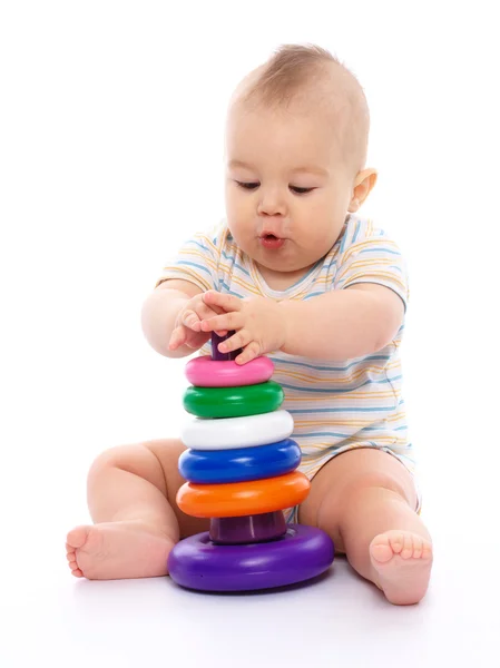 かわいい男の子は白で分離された床に座っている間おもちゃで遊んでください — ストック写真