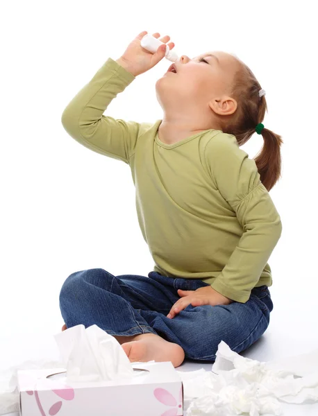 Kleines Mädchen Das Seine Nase Mit Nasenspray Versprüht Während Auf lizenzfreie Stockbilder