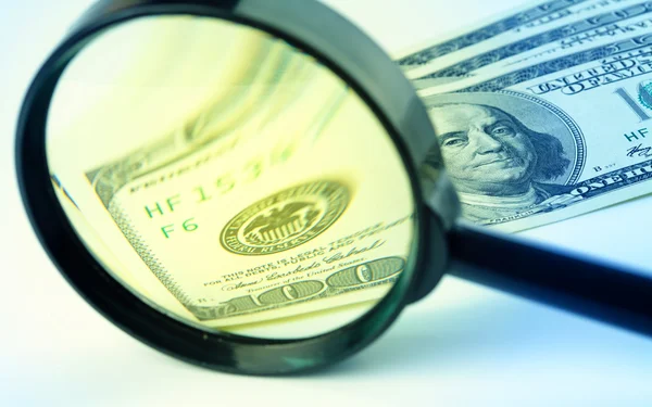 Dollars under a magnifying glass — Stock Photo, Image