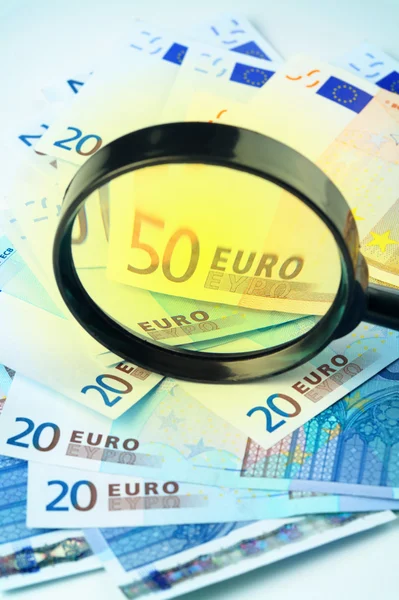 拡大鏡でユーロ通貨の小さなヒープ — ストック写真