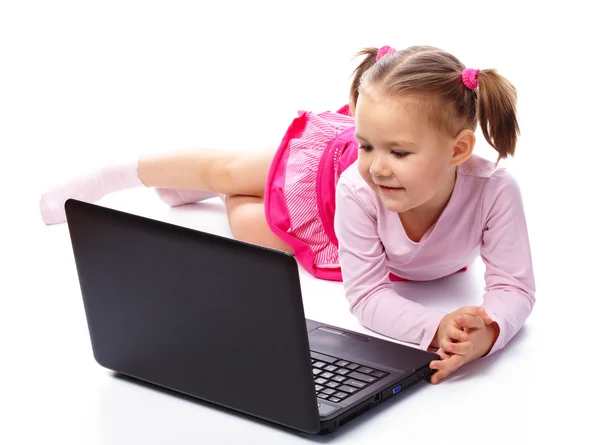 可爱的小女孩坐在地板上用她的笔记本电脑 戴眼镜 白上孤立 — 图库照片