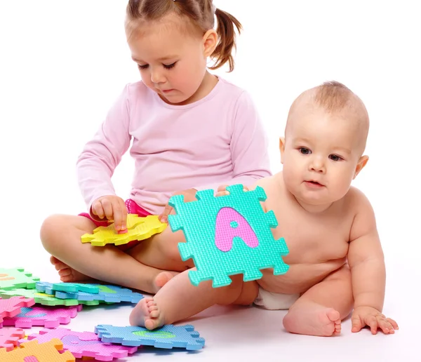 Маленький хлопчик і дівчинка граються з алфавітом — стокове фото