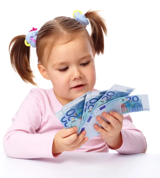 Liten flicka med några papper eurosedlar — Stockfoto