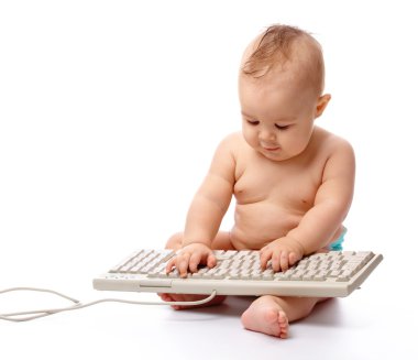 Little child is typing on keyboard clipart