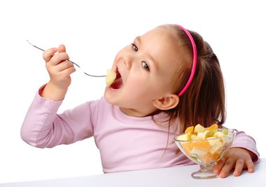 Little girl eats fruit salad clipart