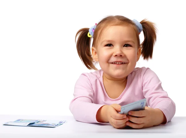 Bambina con poche banconote in euro di carta — Foto Stock
