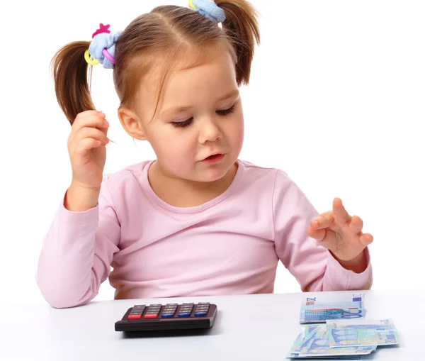 Little girl plays with money — Stock Photo, Image