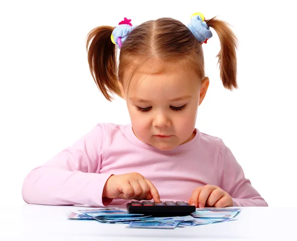 Klein meisje speelt met geld — Stockfoto