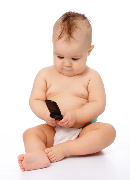 Schattige kleine baby speelt met mobiele telefoon — Stockfoto
