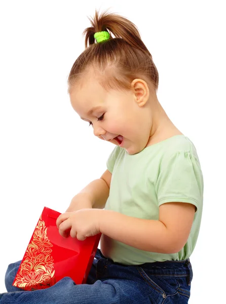 Cute little girl with red shopping bag — Stock Photo, Image