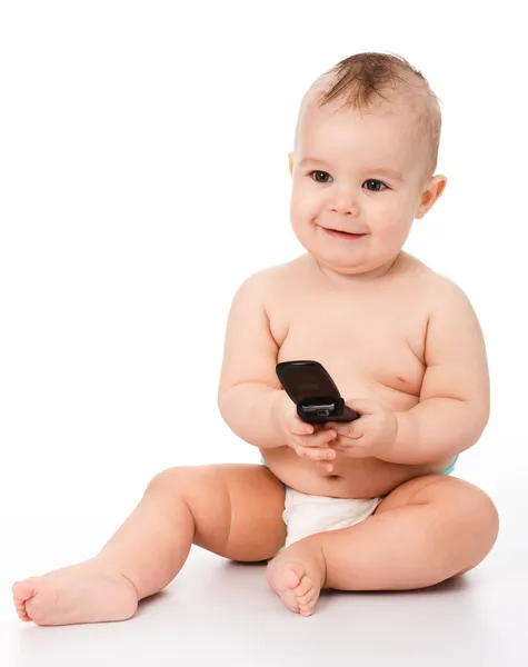 Šťastné dítě hraje s mobilním telefonem — Stock fotografie