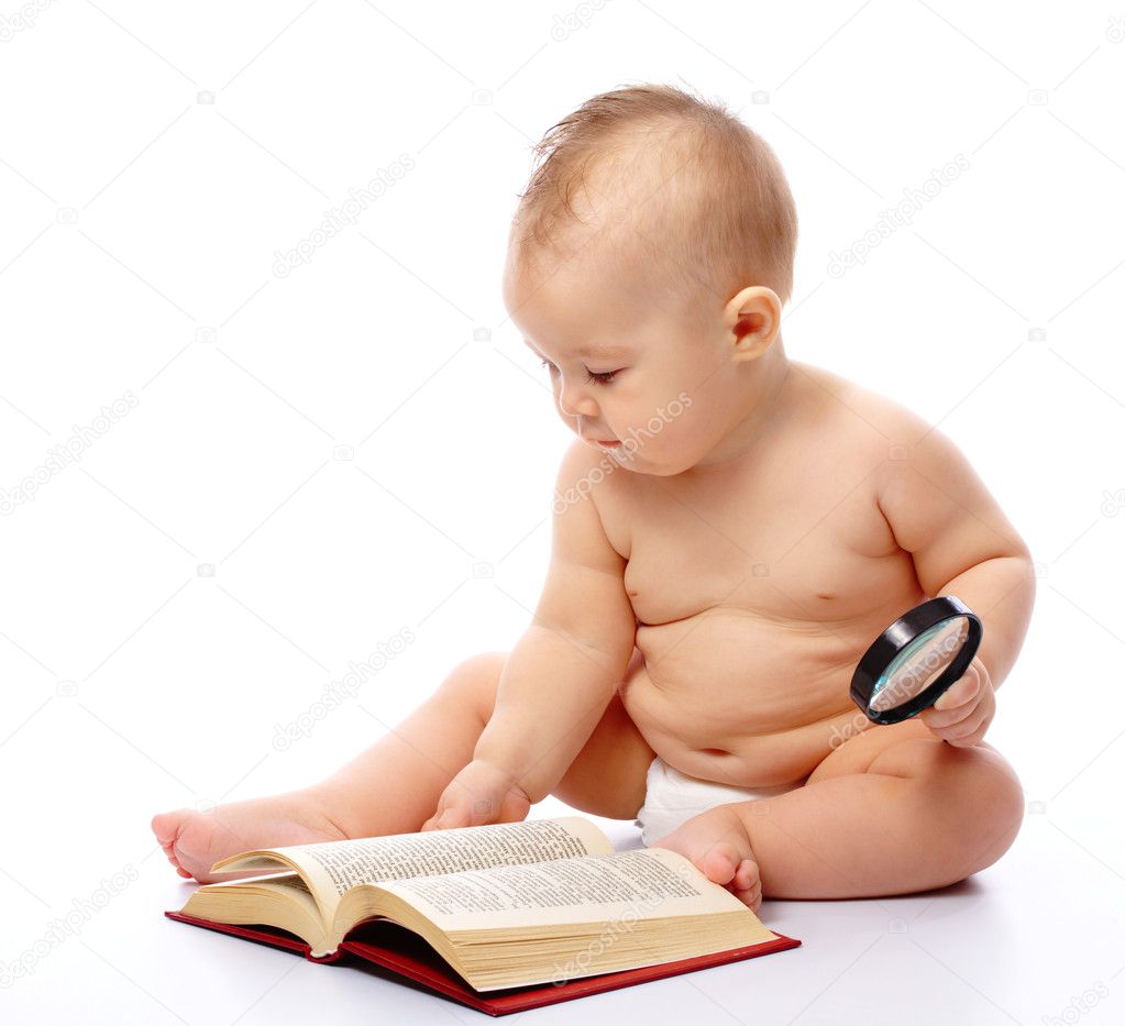 Little child play with book and magnifier