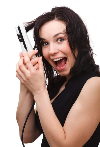 Woman is screaming while using hair straightener — Stock Photo, Image
