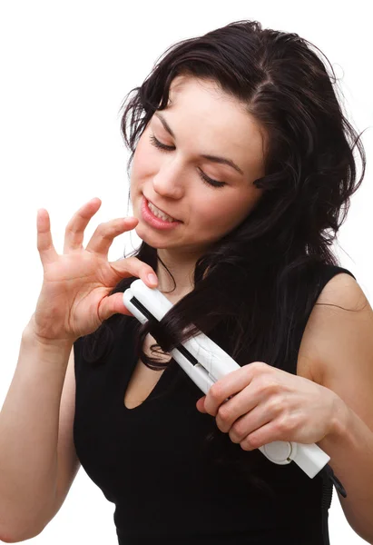 Woman is using hair straightener — Stock Photo, Image