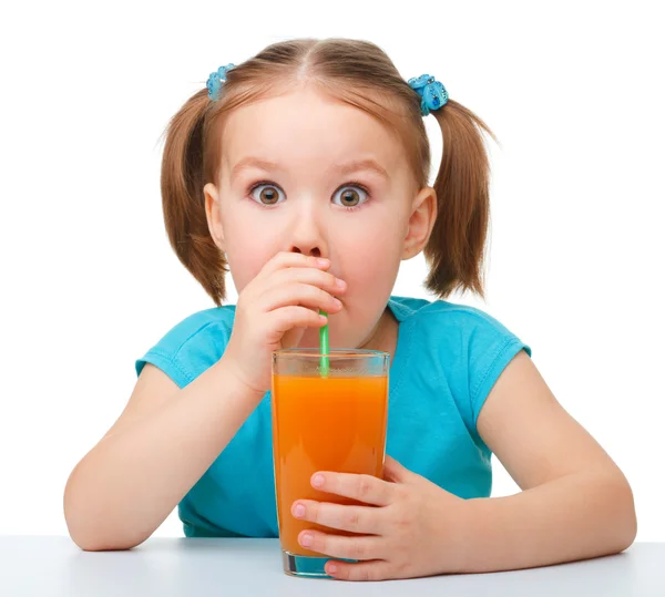 Malá holka pije pomerančovou šťávu — Stock fotografie