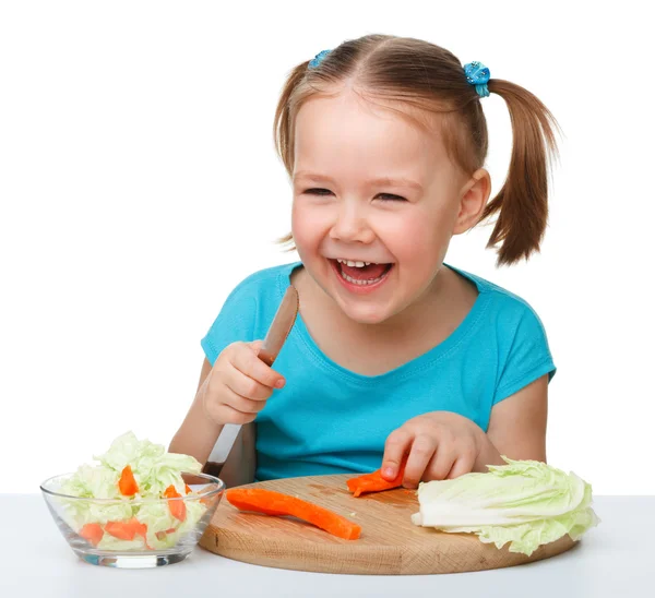 Niña está cortando zanahoria para ensalada —  Fotos de Stock