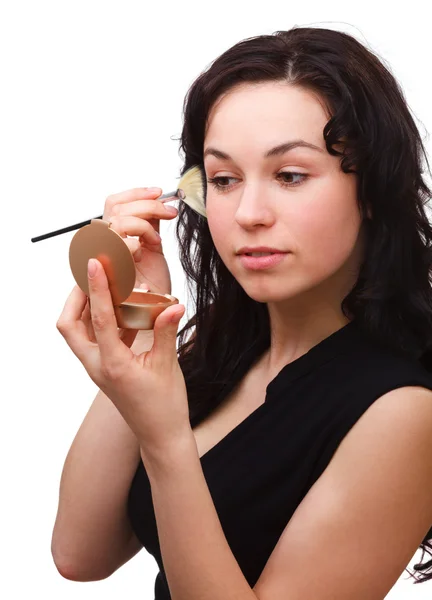 Girl is applying rouge while looking at mirror — Stock Photo, Image