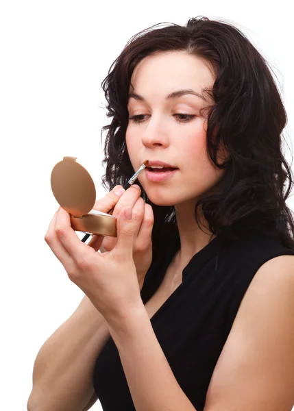 Vrouw is lipgloss toe te passen terwijl het zoeken in spiegel — Stockfoto