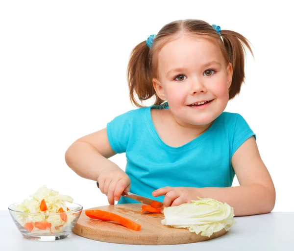 Klein meisje is snijden wortel voor salade — Stockfoto