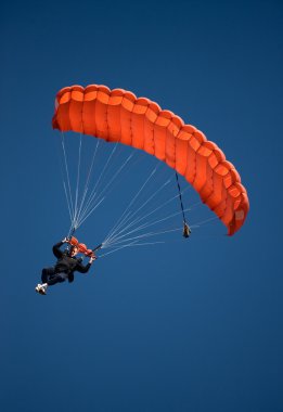 Red parachute against blue sky