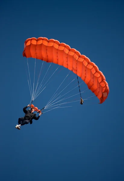 Roter Fallschirm gegen blauen Himmel — Stockfoto
