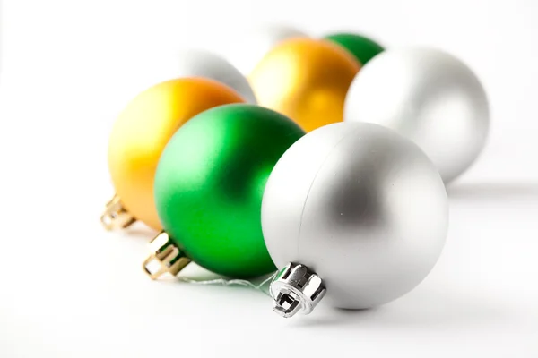 Bugigangas de Natal verdes, douradas e prateadas em branco — Fotografia de Stock