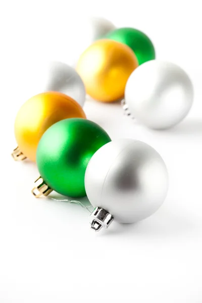Zelené, zlaté a stříbrné vánoční ozdoby na bílém pozadí — Stock fotografie