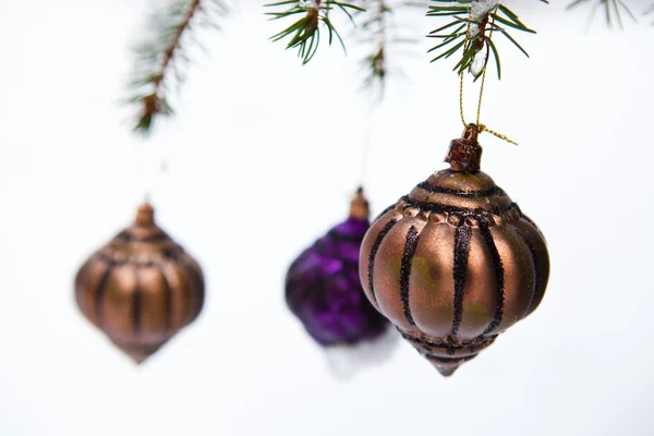 Christmas baubles on a snowy pine — Stock Photo, Image