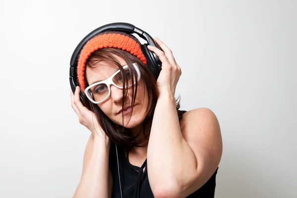 stock image Young woman listening music with headphones. Studio shot.