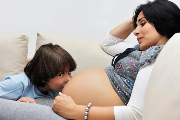 Młody chłopak całuje brzuch w ciąży — Zdjęcie stockowe