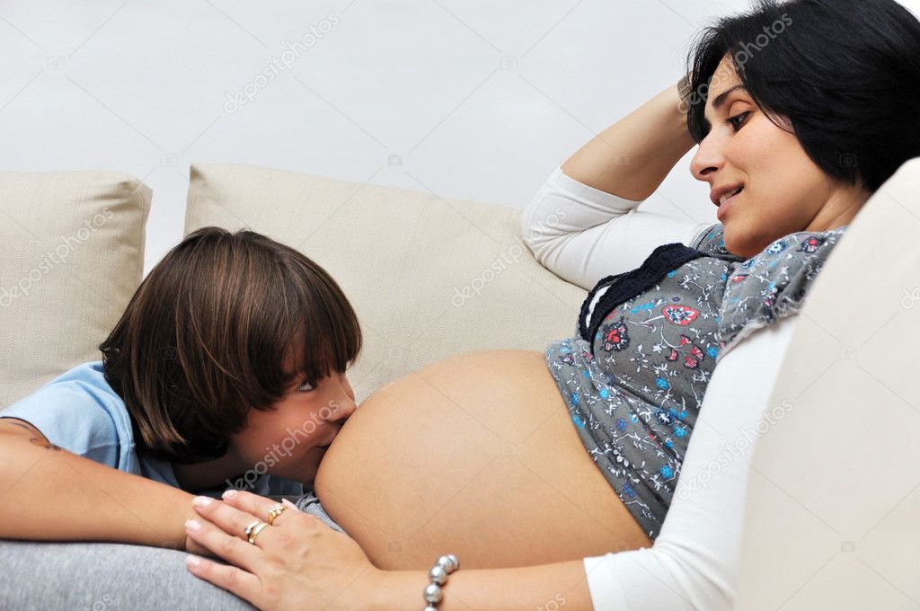 Young boy kissing pregnant belly