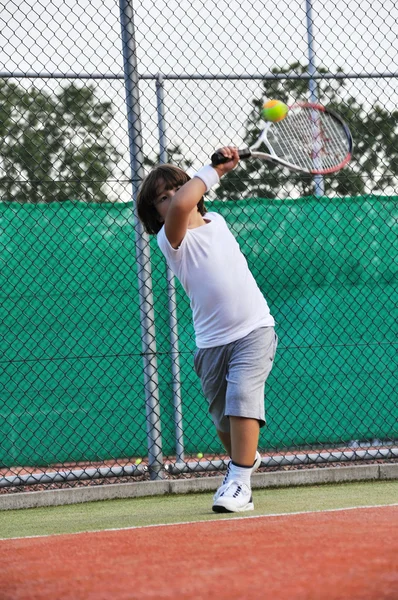 Mladý chlapec hrát tenis — Stock fotografie