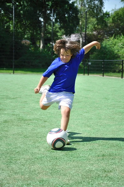Jonge jongen schieten voetbal — Stockfoto