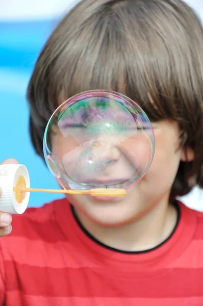 Маленький хлопчик дме мильні бульбашки — стокове фото