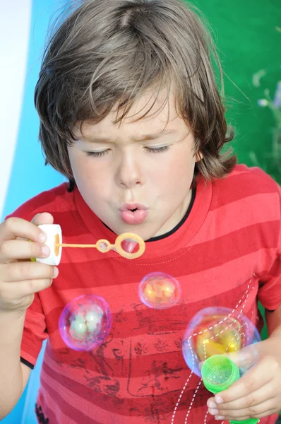 Kleiner Junge pustet Seifenblasen — Stockfoto