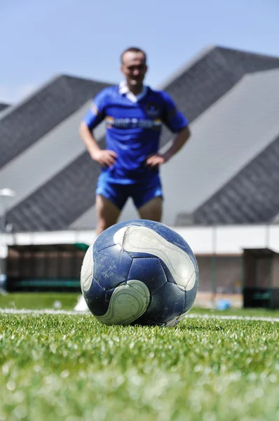Joueur de football et ballon sur le terrain d'herbe — Photo