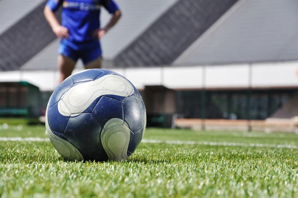 Joueur de football et ballon sur le terrain d'herbe — Photo