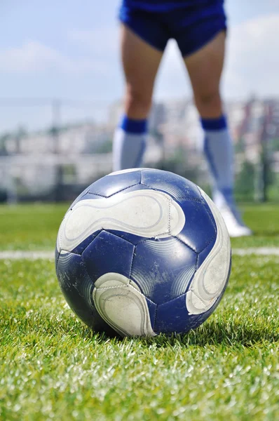 Футболист и мяч на травяном поле — стоковое фото